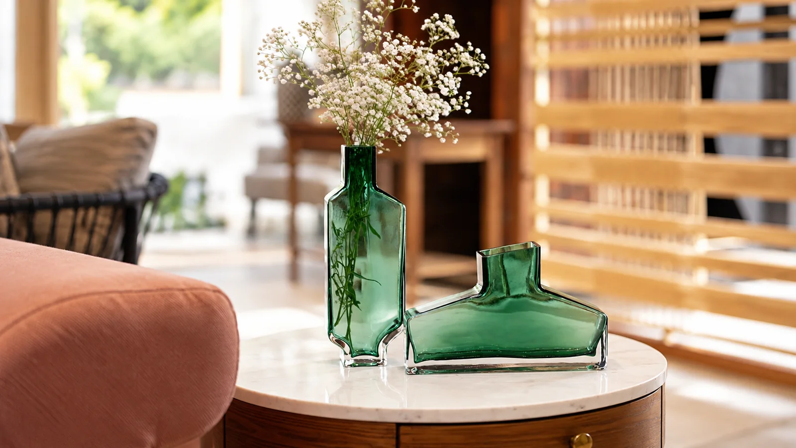 Bestsellers banner: Green glass vases with baby's breath on a marble side table