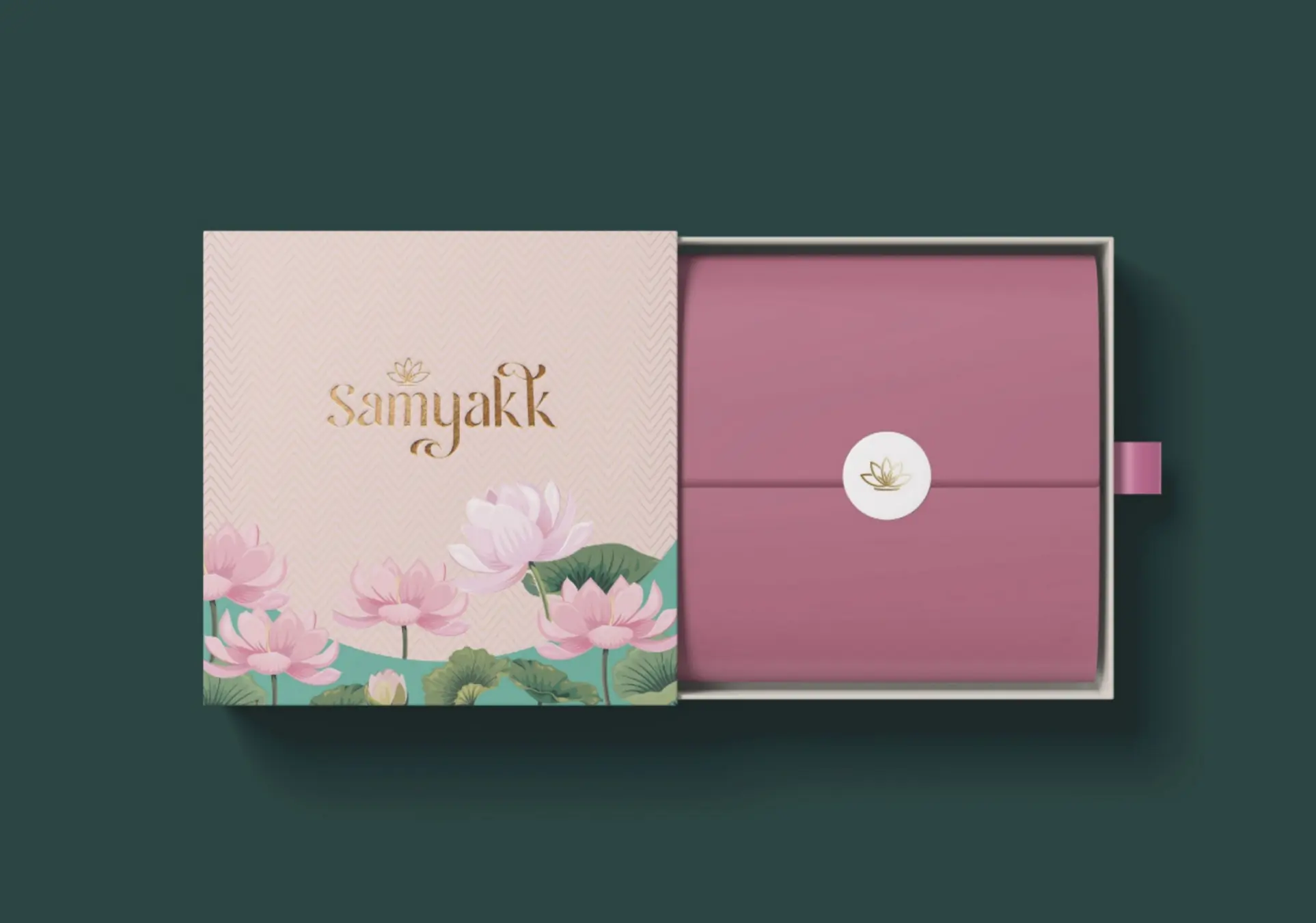 Bridal box from above: lotus print sleeve sliding open onto a mauve wrap with the lotus seal