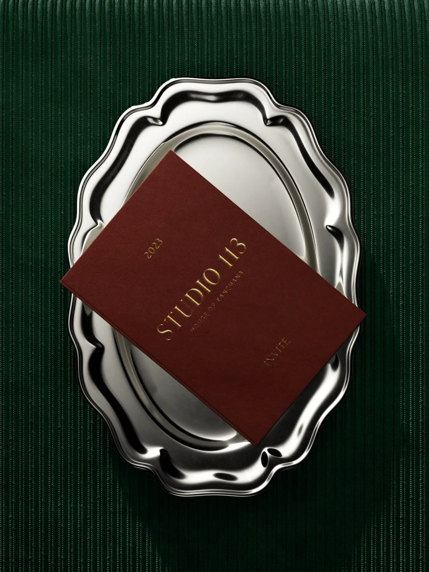 Burgundy Studio 113 invitation with gold foil on a scalloped silver tray