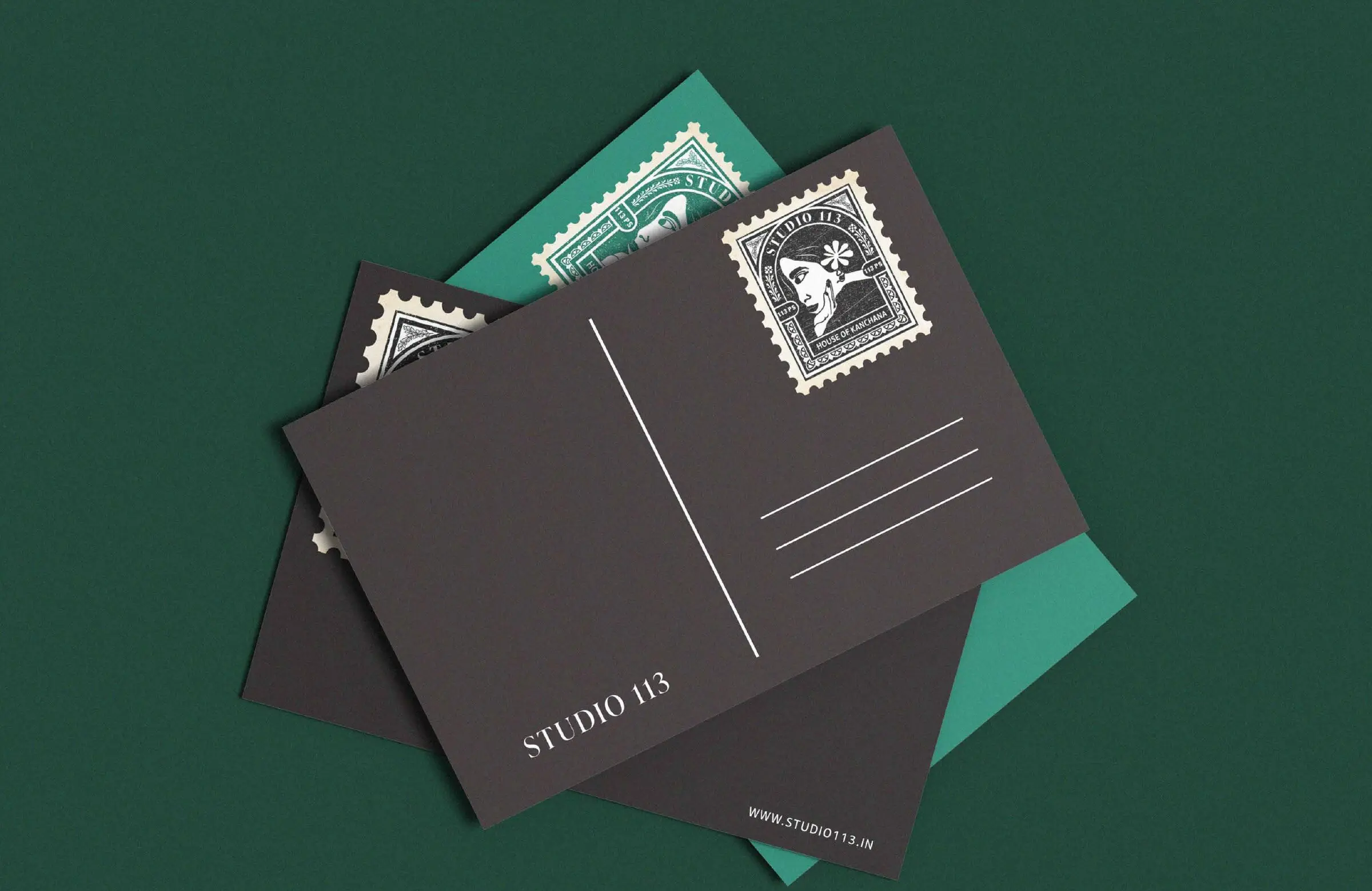 Studio 113 postcards with the stamp logo on teal