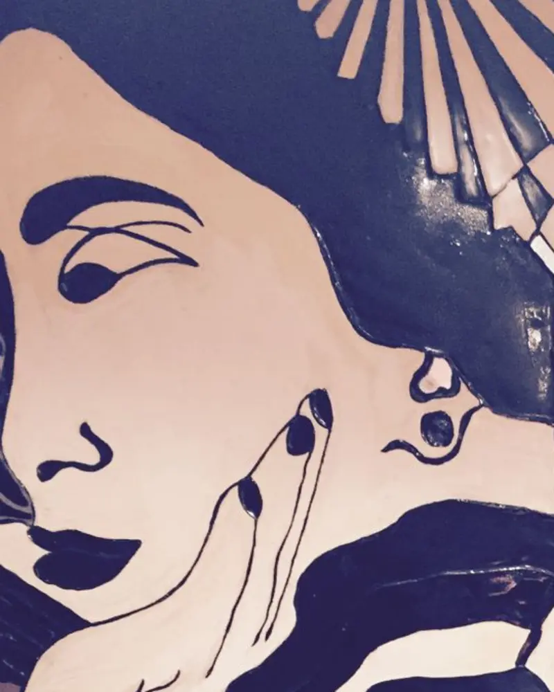 Detail of the mural: a woman resting her cheek on her hand, wearing an earring