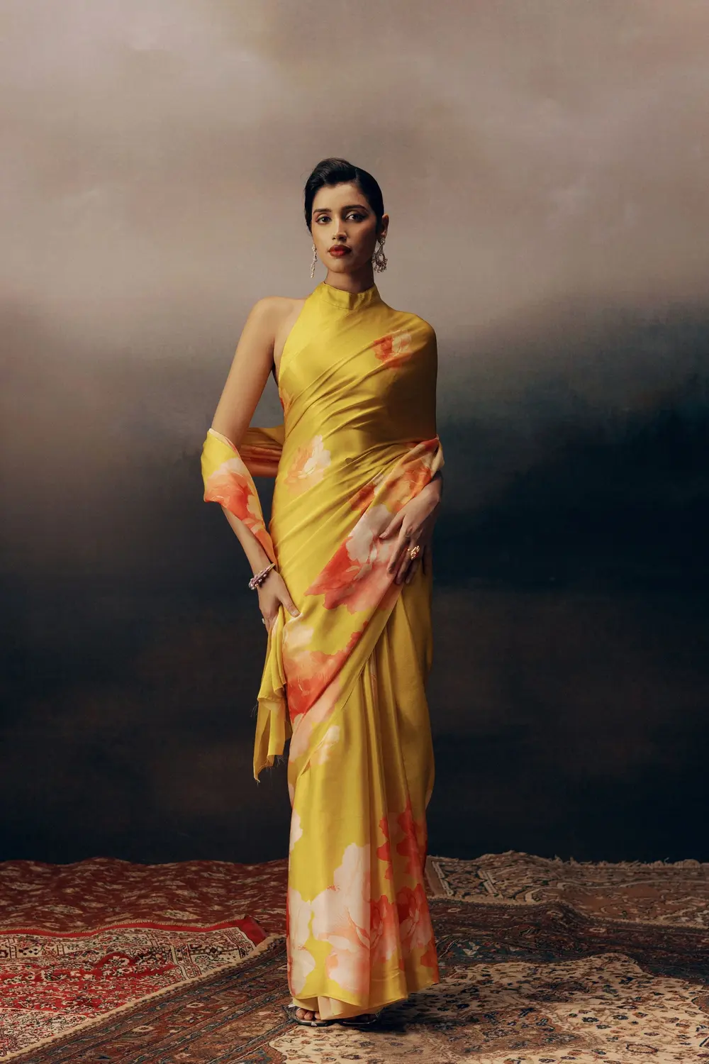 Model in a yellow floral saree with a high neck on a Persian rug