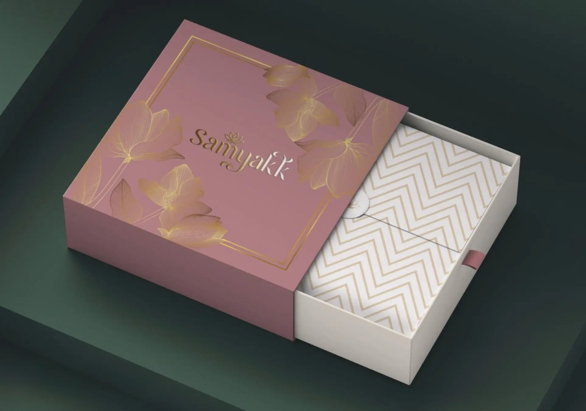 Saree box: mauve sleeve with gold line lotuses, opening onto a chevron tray