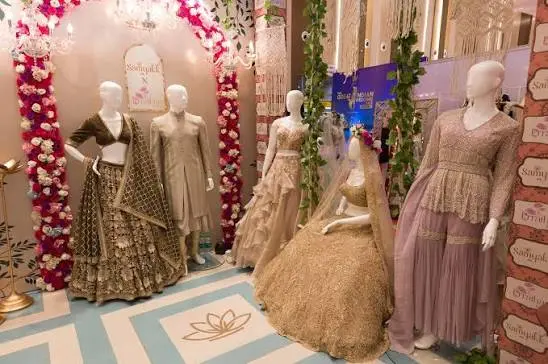 Bridal and occasion wear on mannequins, with the Samyakk lotus inlaid in the floor and Samyakk signage on the pillars